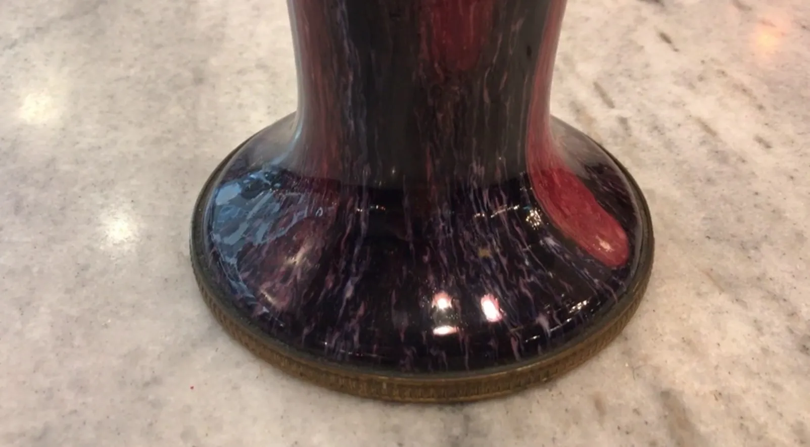 Base di ceramica antica con tonalità viola e rosse, elegante