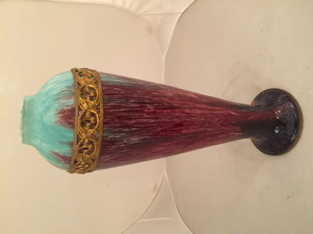 Antique ceramic vase with blue and red design, accented with a golden rim.