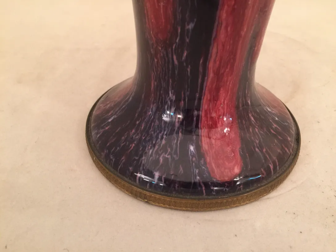 Antike Keramikvase mit rotem und schwarzem Design, platziert in einer neutralen Umgebung.