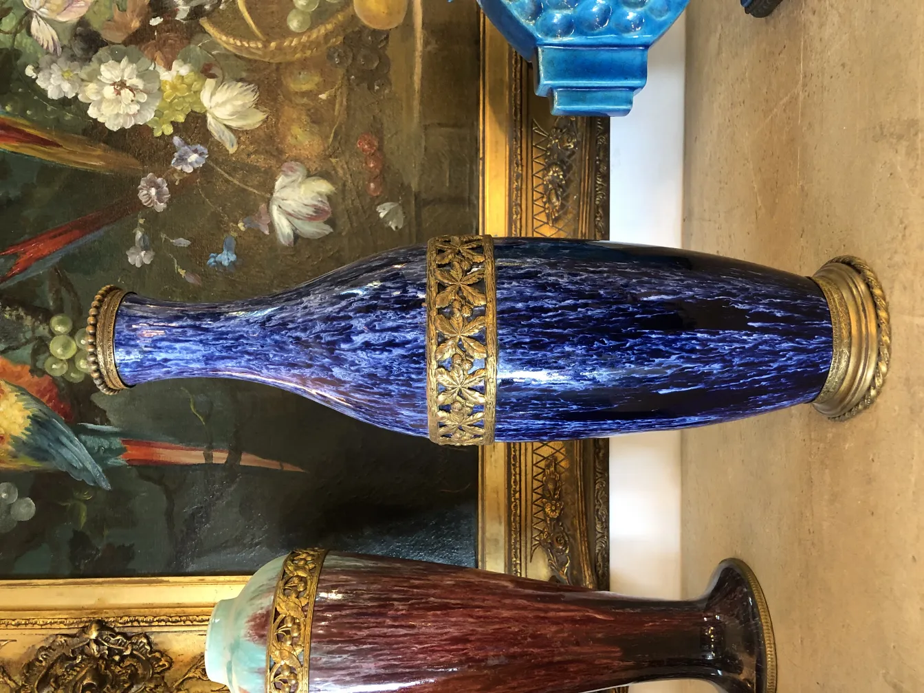 Antique blue ceramic vase with golden details and artistic background.