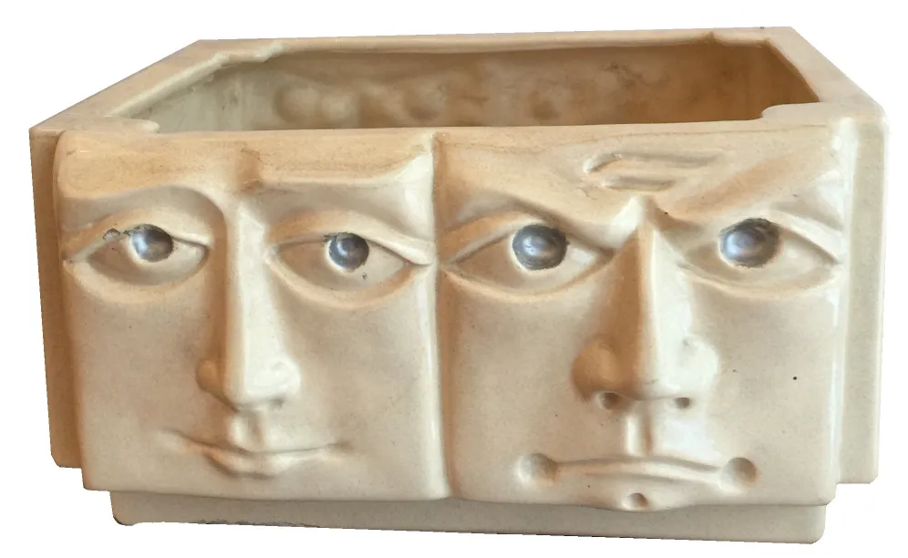 Ceramica antica con volti scolpiti, che mostrano espressioni uniche.