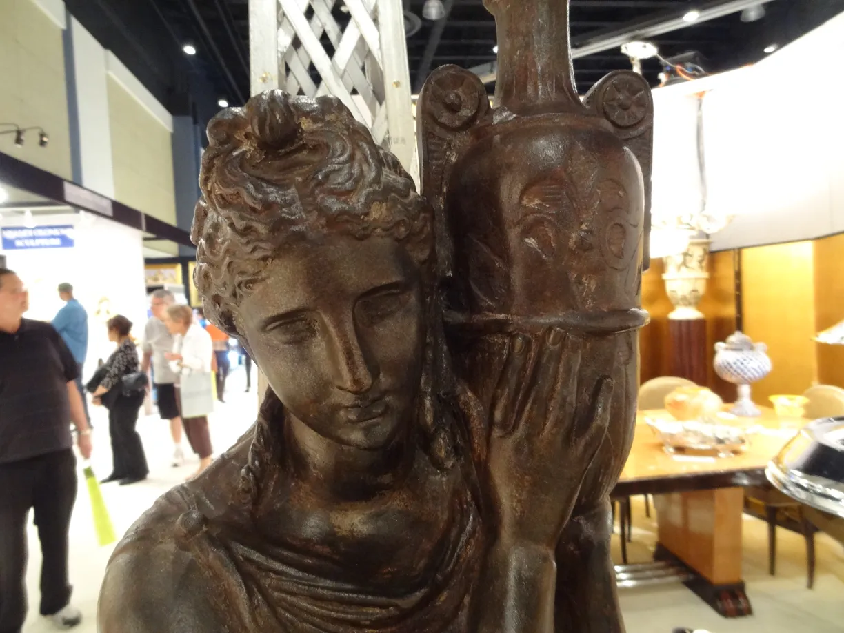 Escultura antigua de Val D´Osne, detalle de figura femenina sujetando un objeto decorativo.