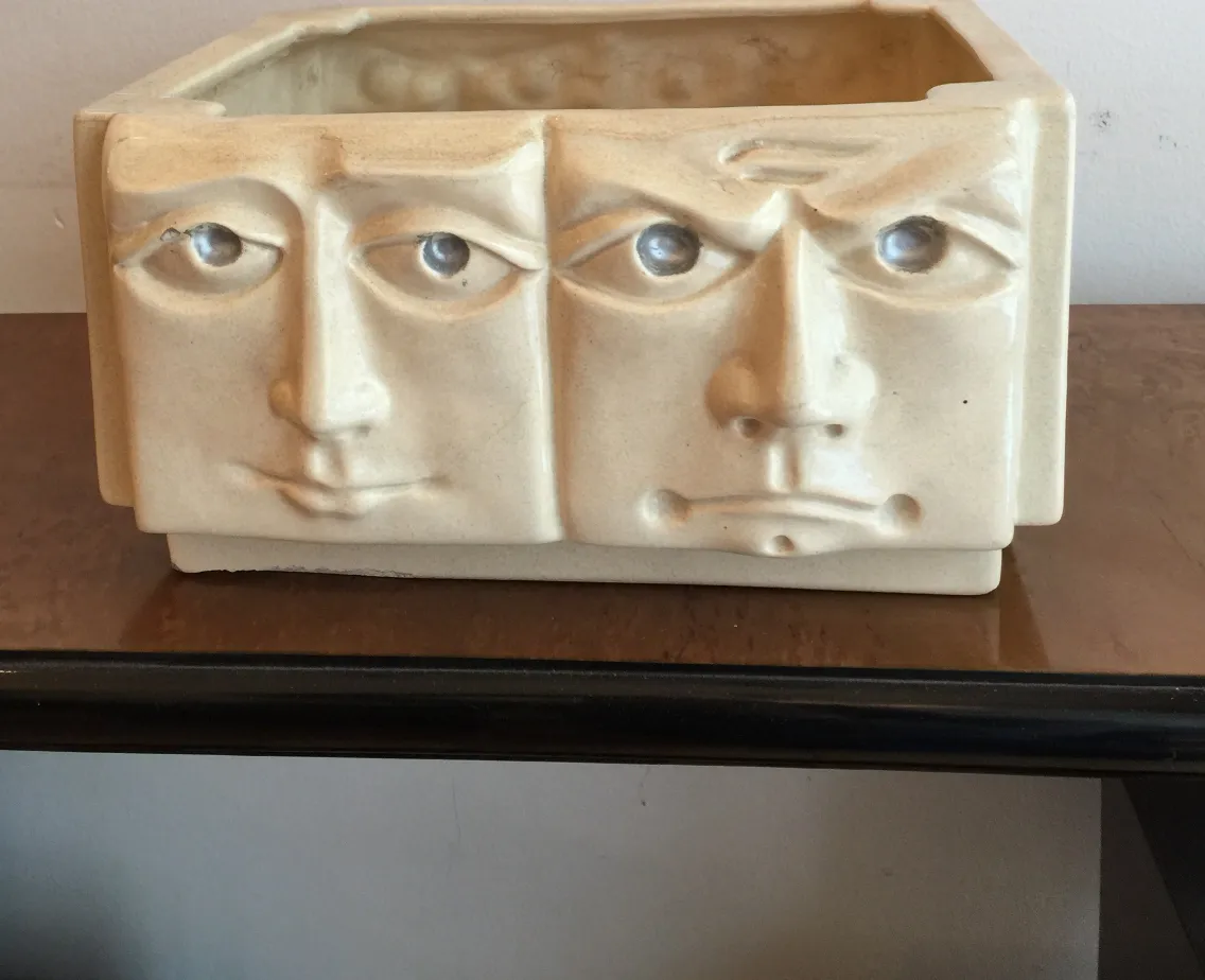 Ancient ceramic piece featuring expressive faces