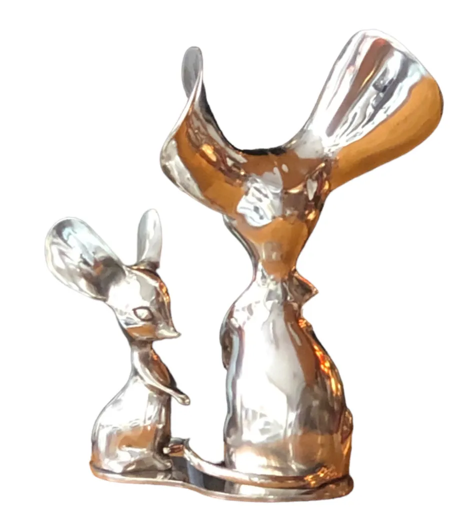 Escultura antigua de dos figuras de animales brillantes.