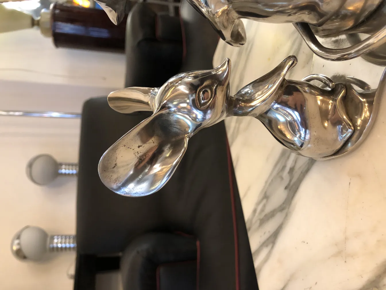 Escultura antiga de coelho em metal, em um ambiente elegante.