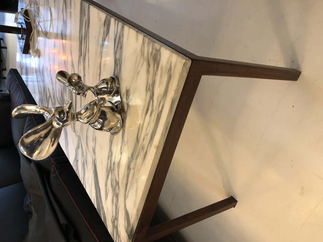 Escultura antigua de conejos en mesa de mármol