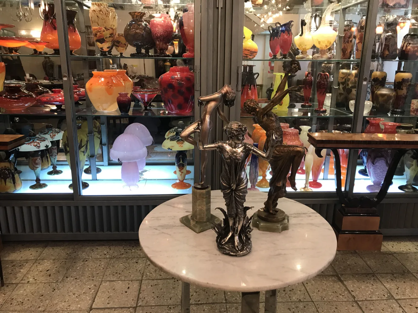 antike Skulptur einer weiblichen Figur vor buntem Hintergrund