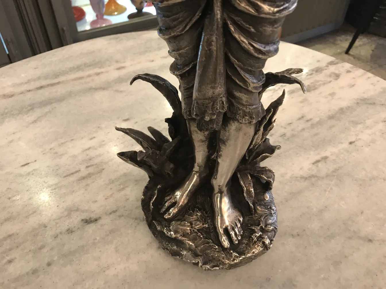 Scultura antica di figura su base naturale, dettagli realistici.