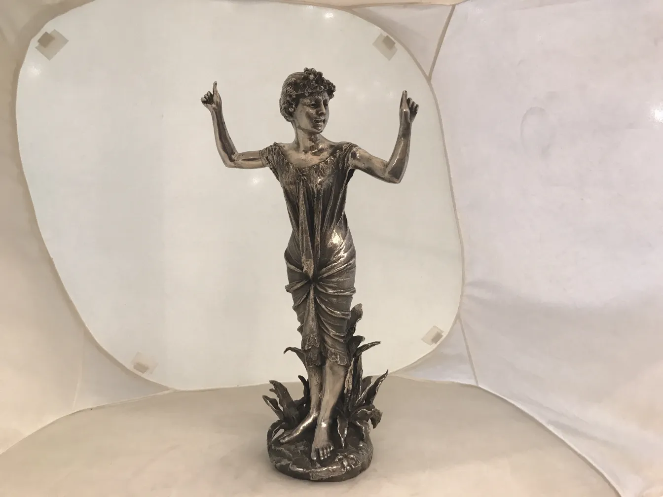 scultura antica di una donna con braccia alzate in un ambiente luminoso