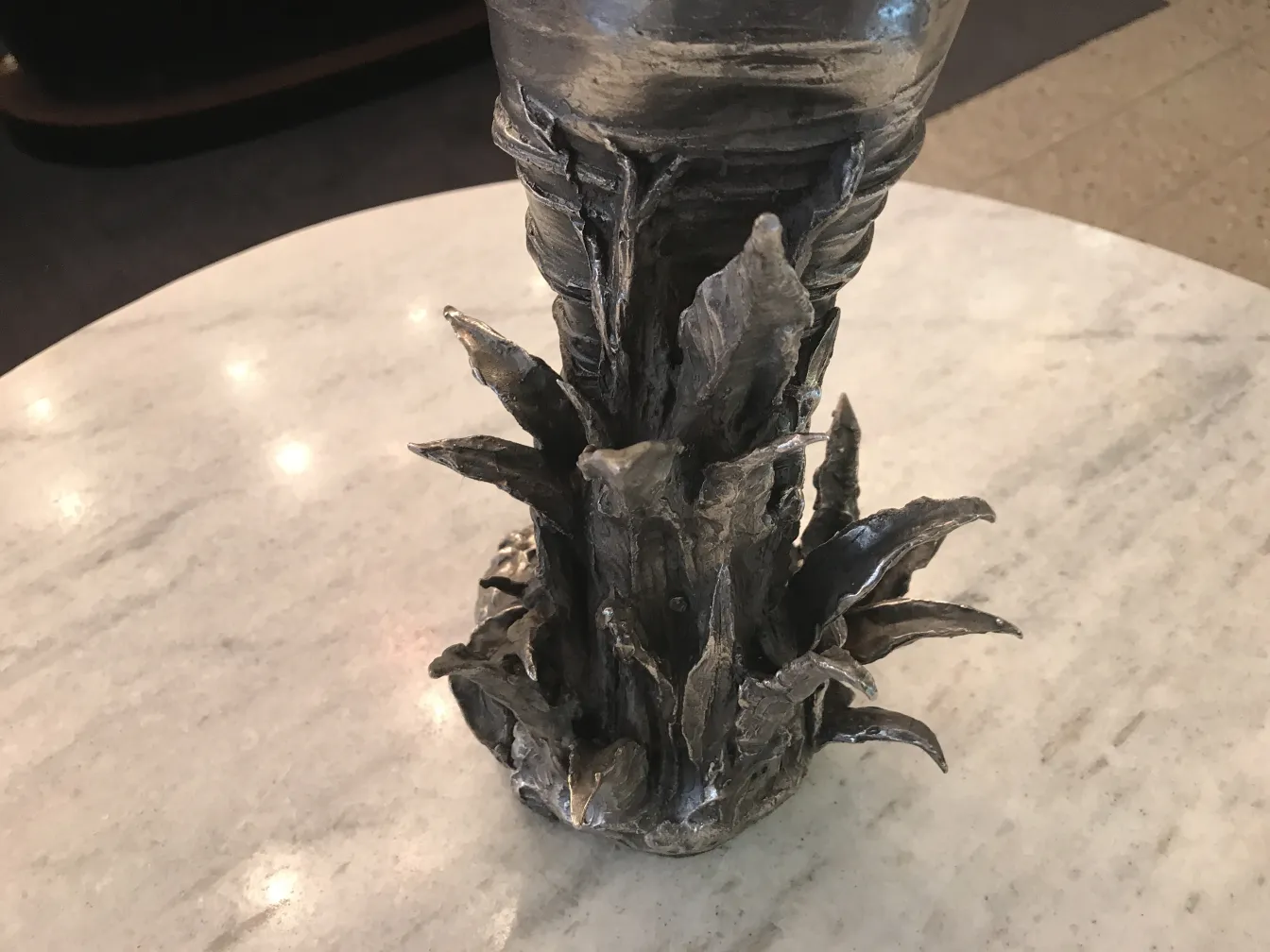 ancient sculpture with intricate base in an elegant setting