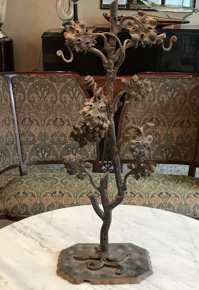 Scultura antica di un albero adornata con frutti in un ambiente elegante.