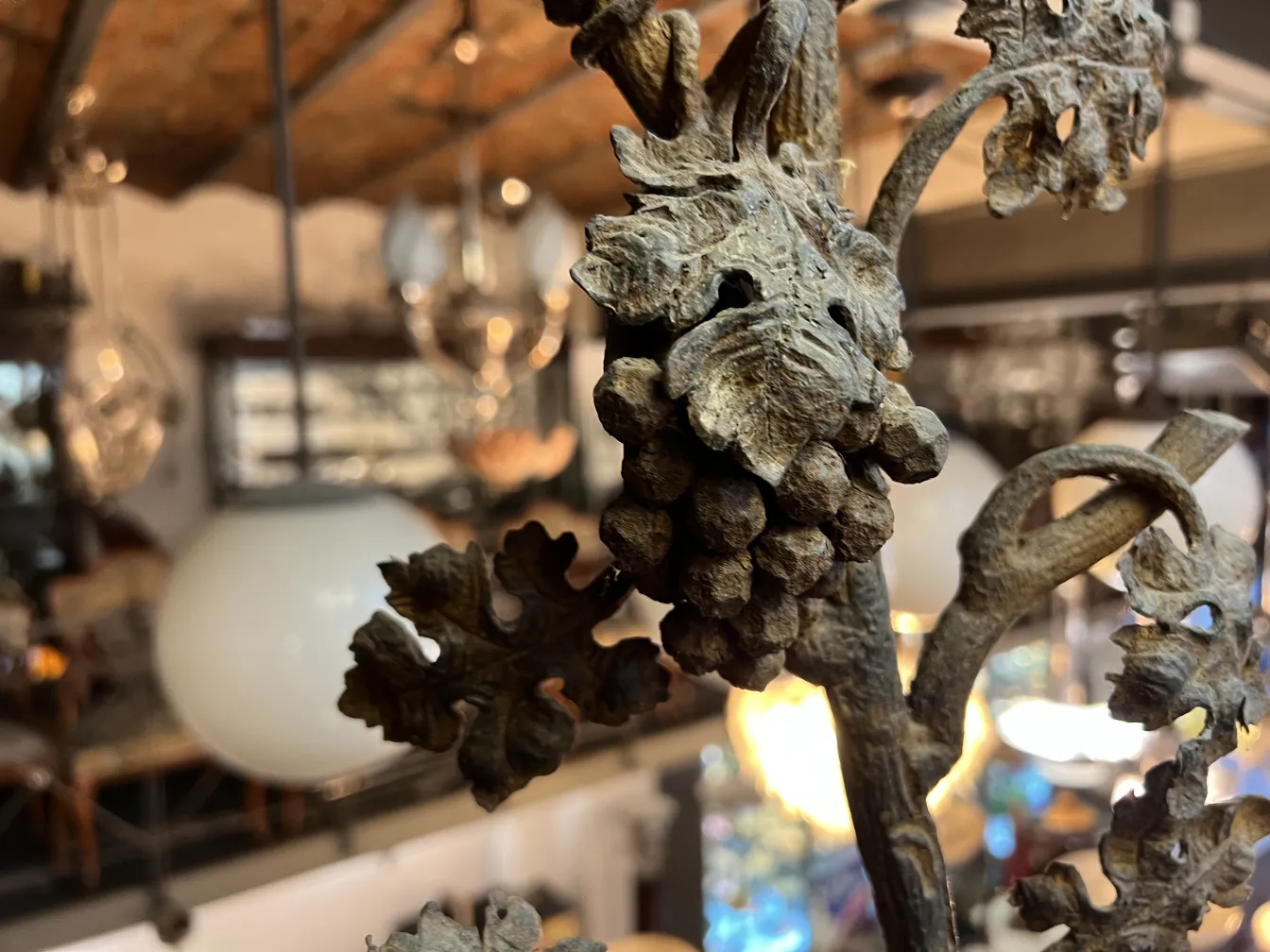 店舗の背景がある、葉とブドウの詳細を特徴とする古い植物彫刻のクローズアップ。