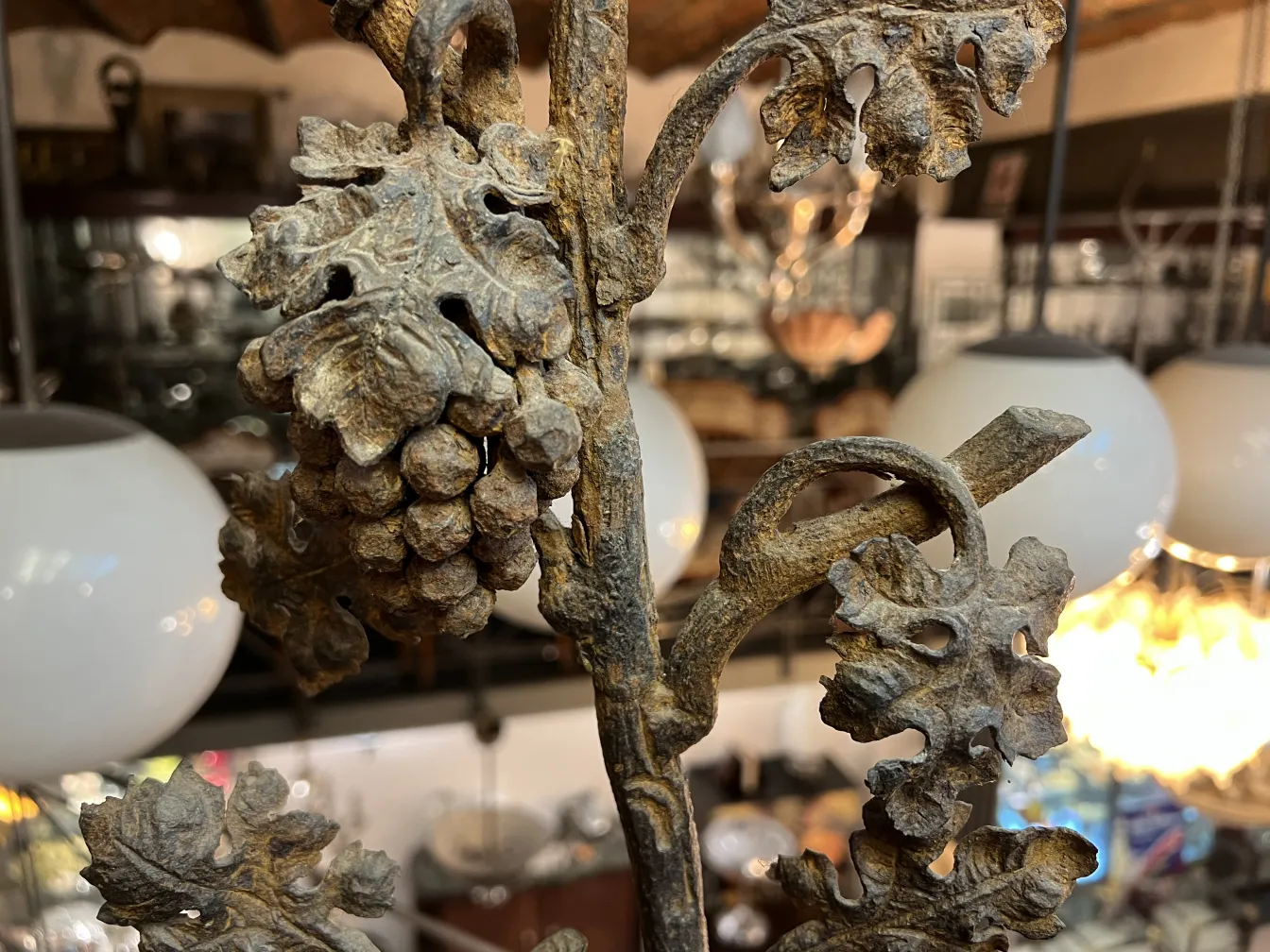 escultura antigua con detalles de hojas y uvas en un ambiente elegante