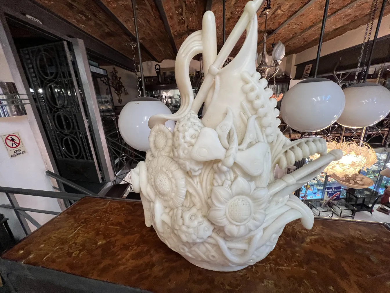 Antique sculpture decorated with flowers and organic shapes in a modern setting.