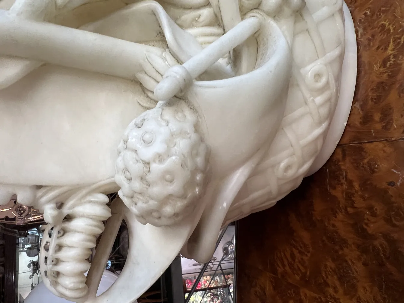 Escultura antiga com detalhes intrincados e fundo decorativo.