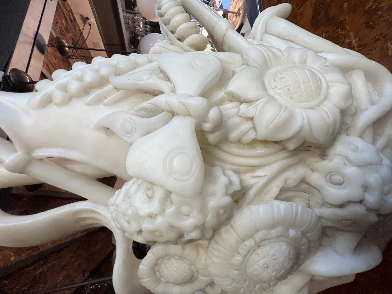 Relief details of an antique white floral sculpture.