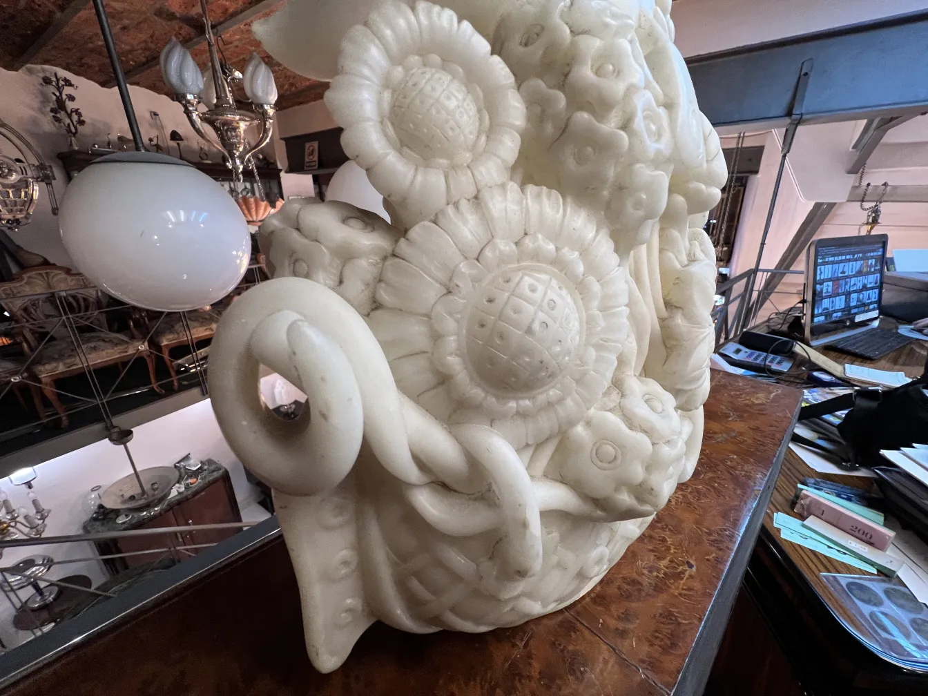 Escultura antigua con detalles florales en un ambiente vintage.