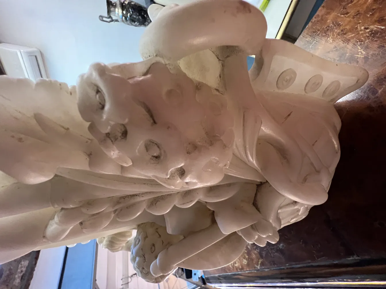 Detalhes intrincados em uma escultura antiga sobre fundo neutro.