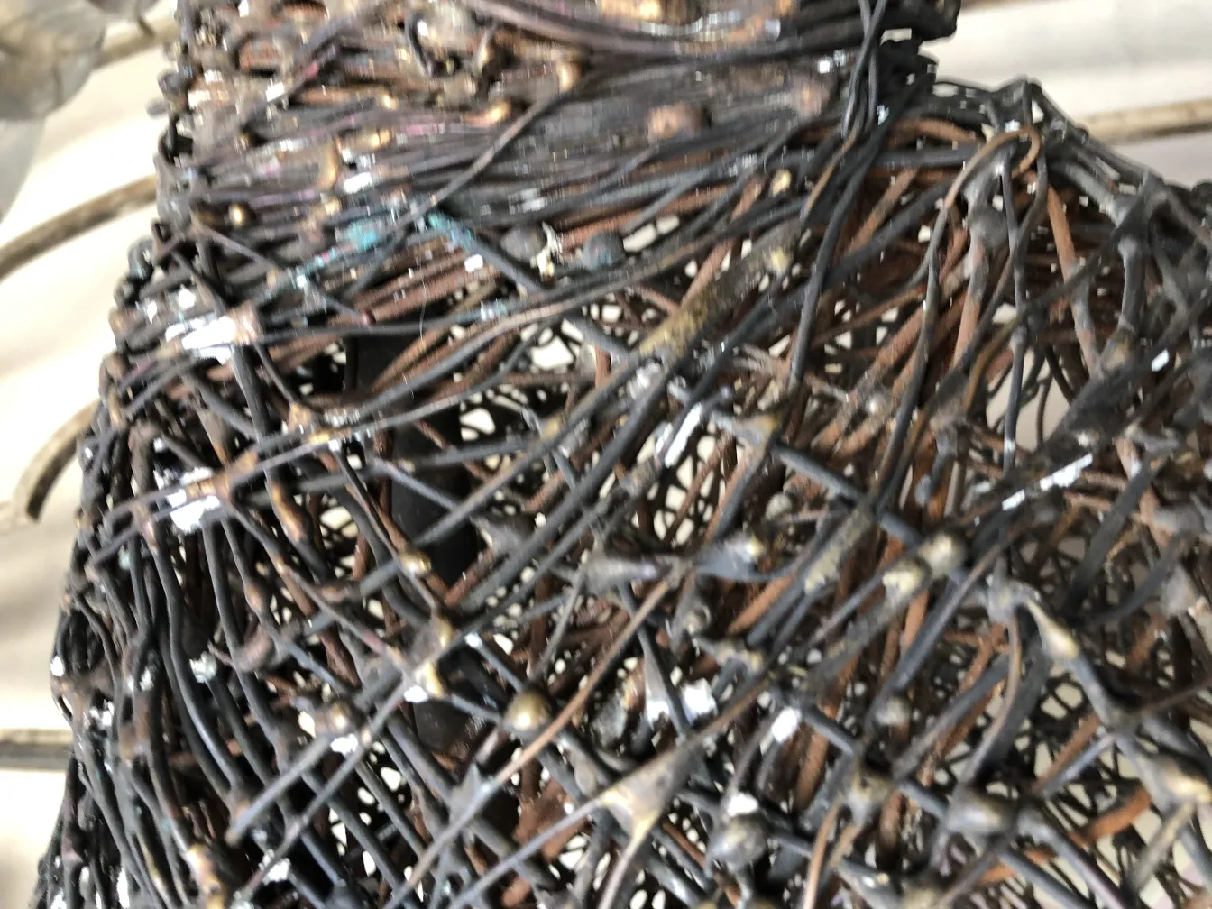 Escultura antiga com design de rede em tons escuros.