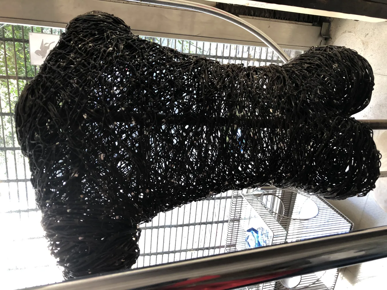 Schwarze zeitgenössische Skulptur mit abstrakter Form, modernes Umfeld.