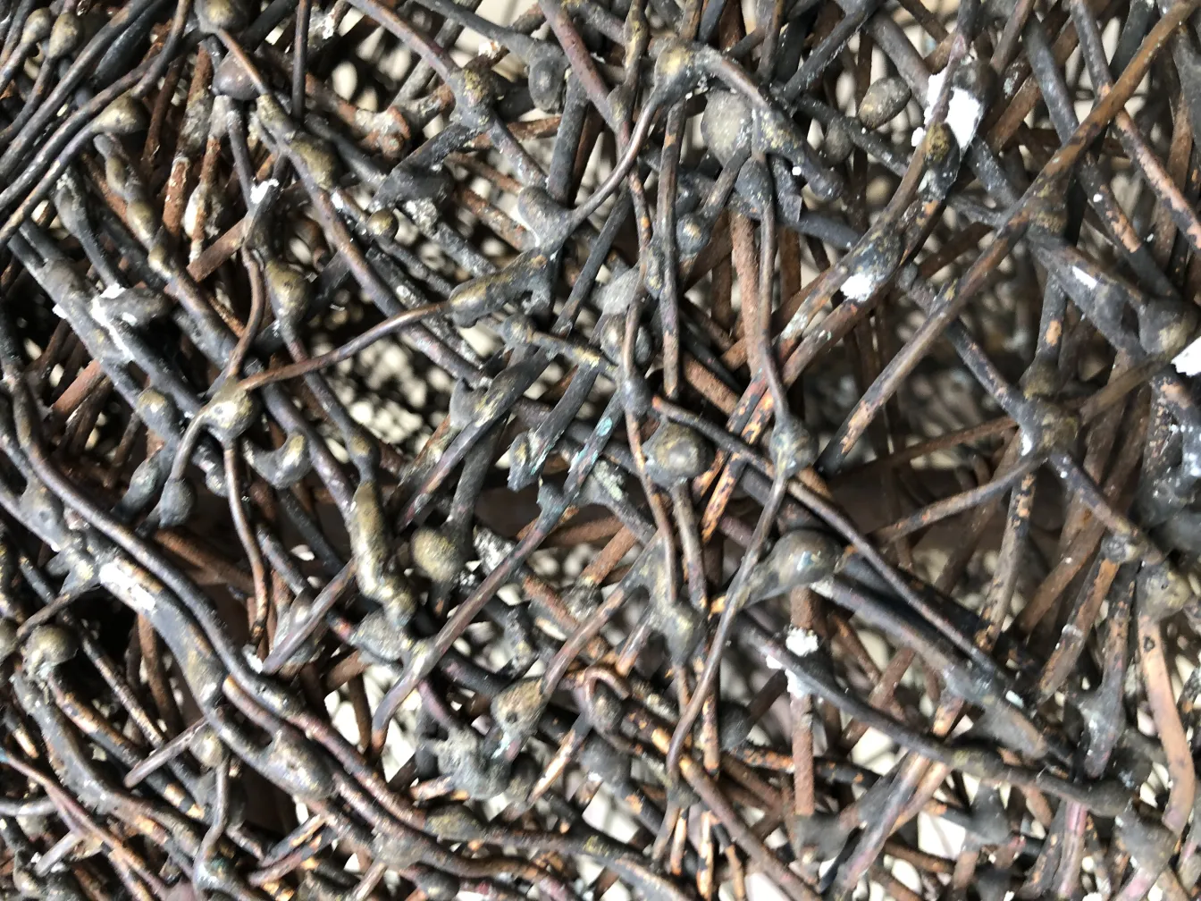 Escultura antigua con líneas entrelazadas y texturizadas.