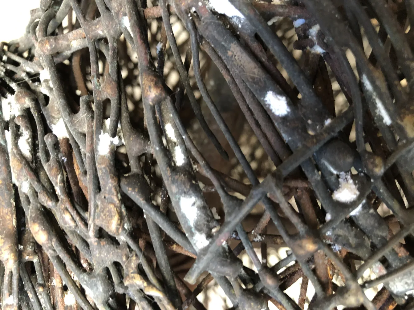 Escultura antiga com formas orgânicas entrelaçadas e detalhes sutis.