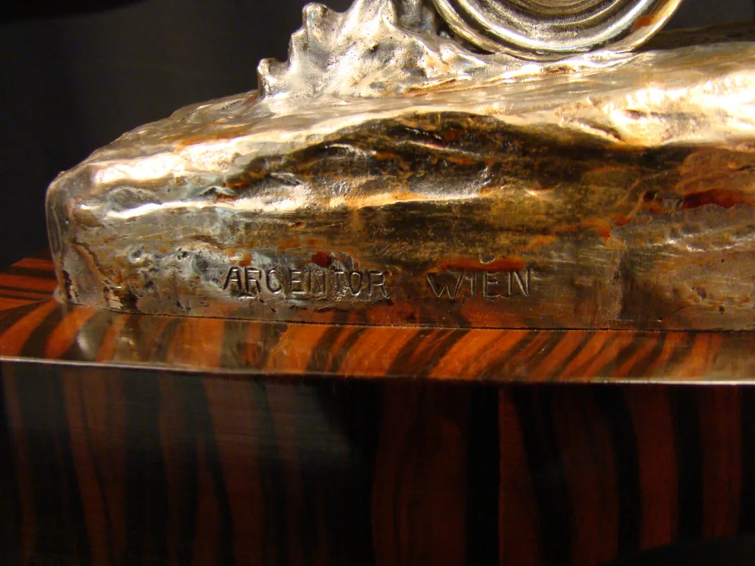 Antique decorative sculpture with silver and wood details.