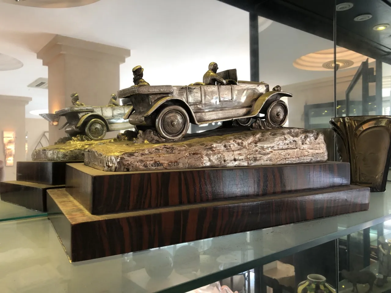 Escultura antigua de automóviles en una base elegante