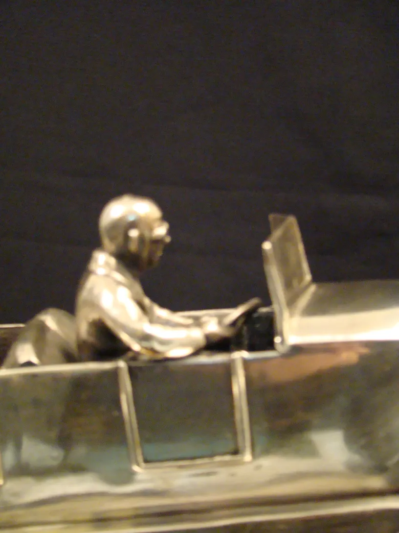 escultura antiga de metal mostrando um motorista