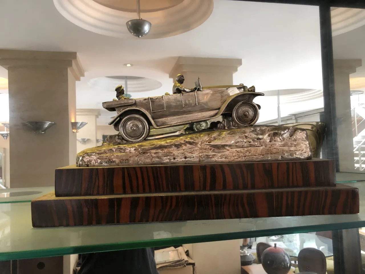 scultura antica di un'auto su base di legno