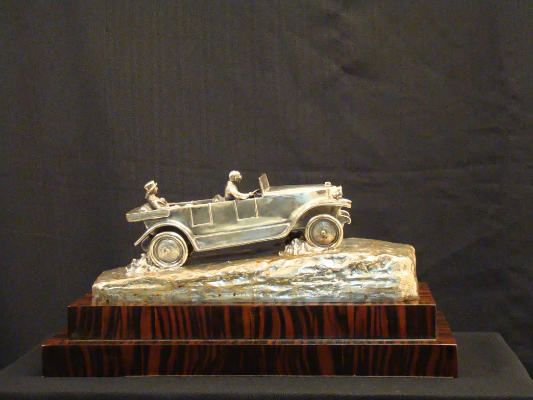 Sculpture antique d'une voiture avec deux figures.
