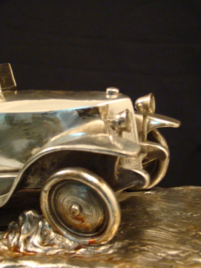 Scultura antica di un'auto in miniatura brillante con dettagli.