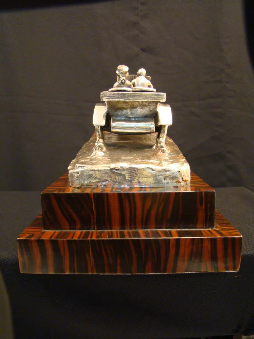 古代彫刻が木製の台座の上に立っている。