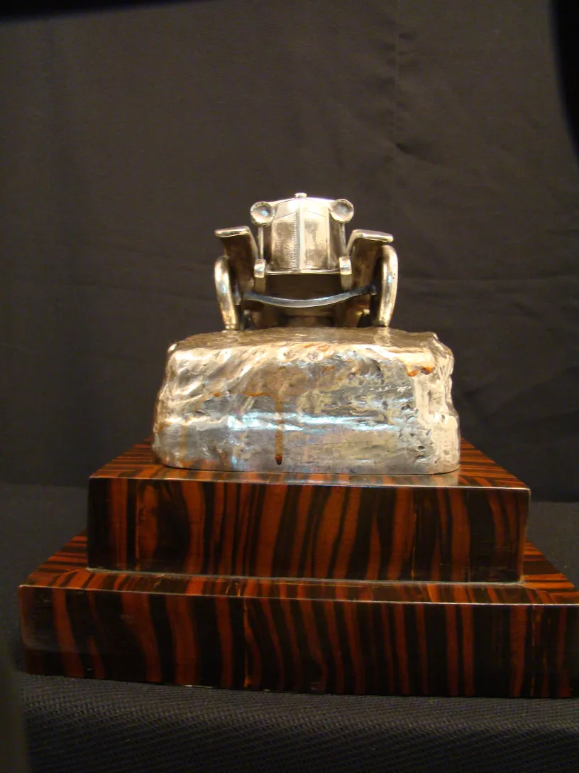 sculpture ancienne d'une voiture sur une base élégante