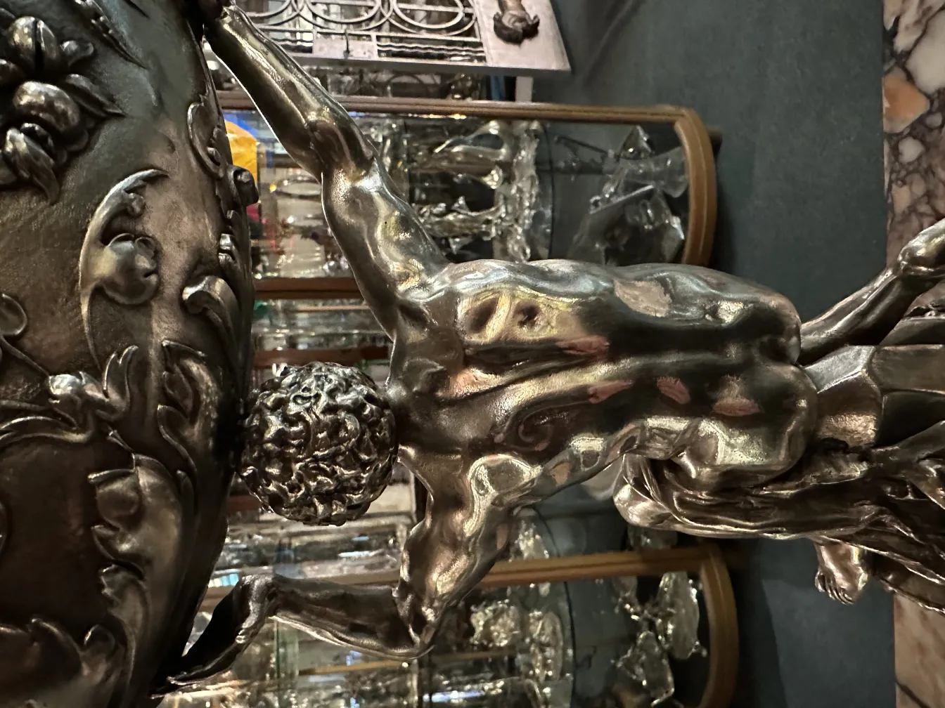 Scultura antica di figura umana con dettagli ornamentali.