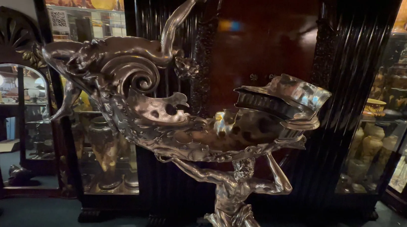 Scultura antica con figura maschile che tiene una ciotola decorativa