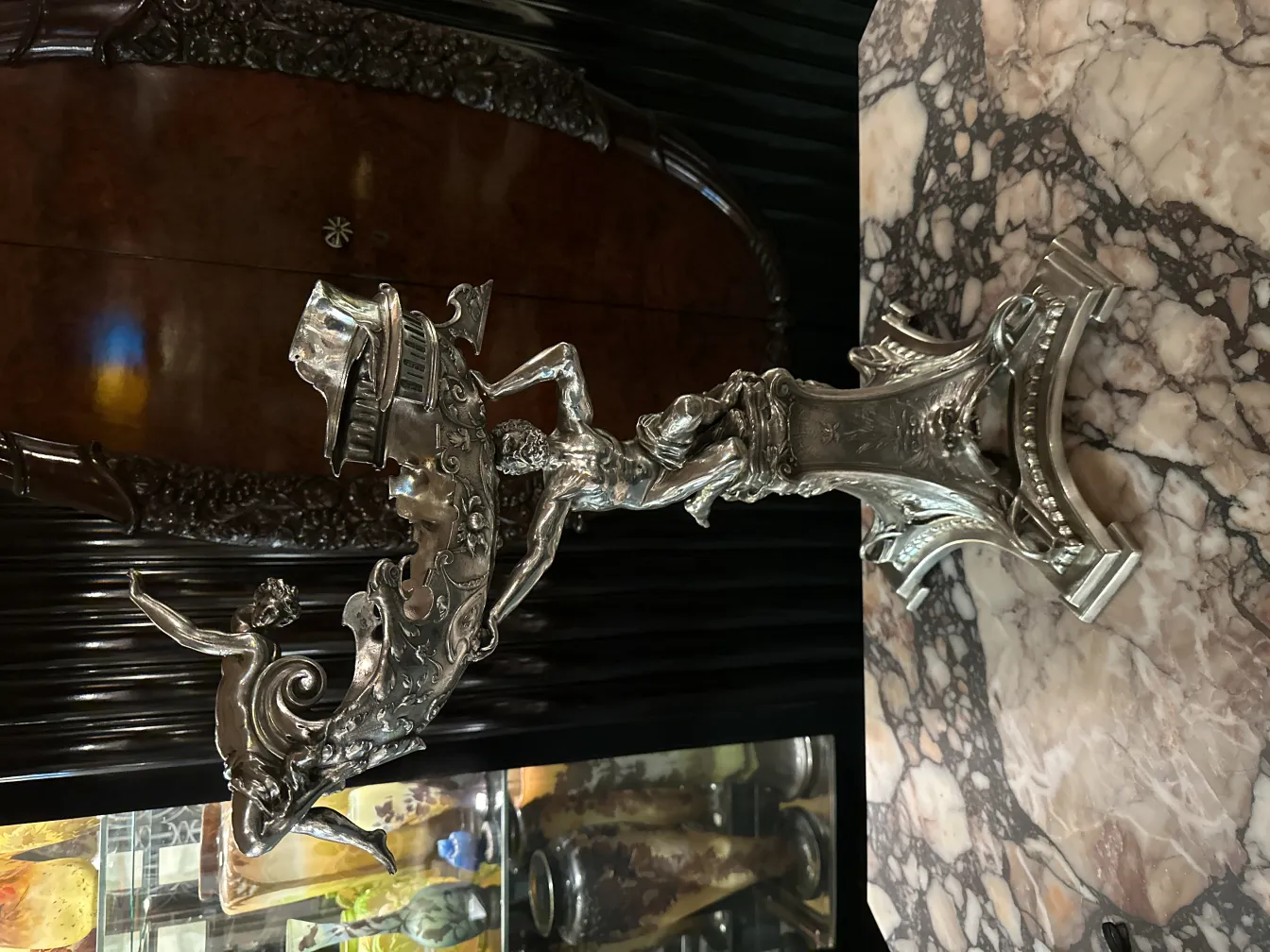 Antique metal sculpture of a human figure with intricate details and decorative motifs.