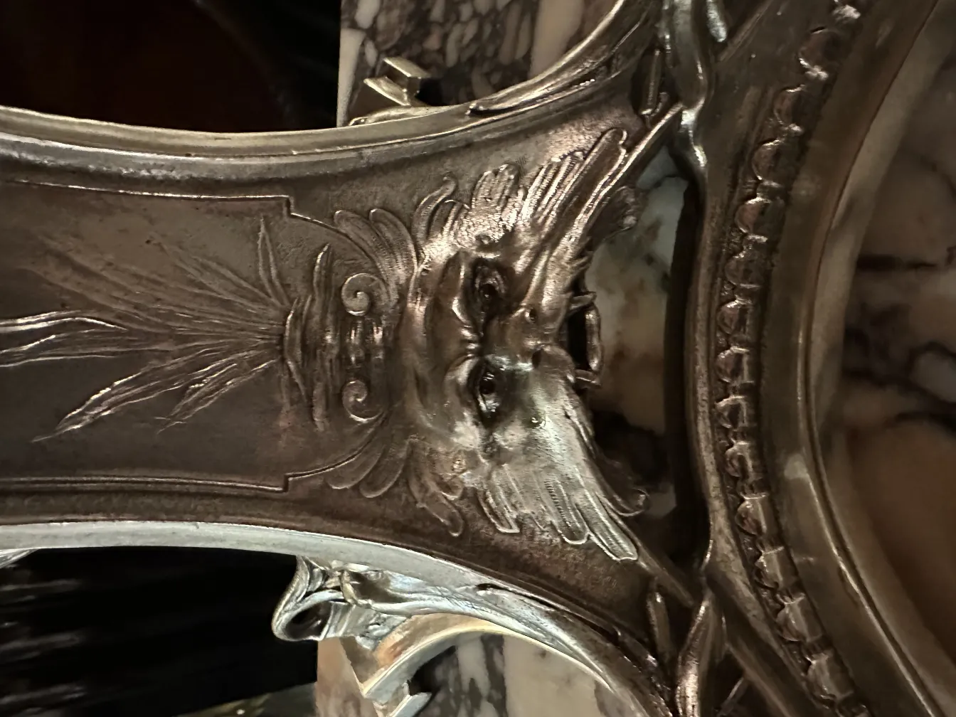 Antike Reliefskulptur mit Gesichtdetails, dunkler Hintergrund.