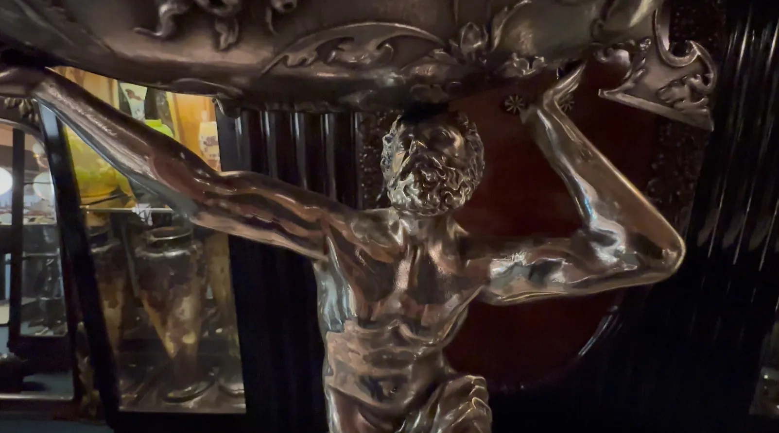 sculpture antique d'un homme soulevant un poids, dans un cadre accueillant