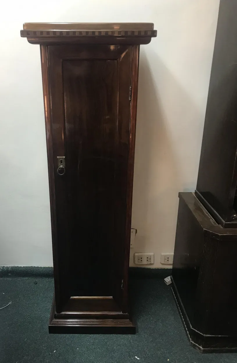 Antique storage column with door, classic setting.