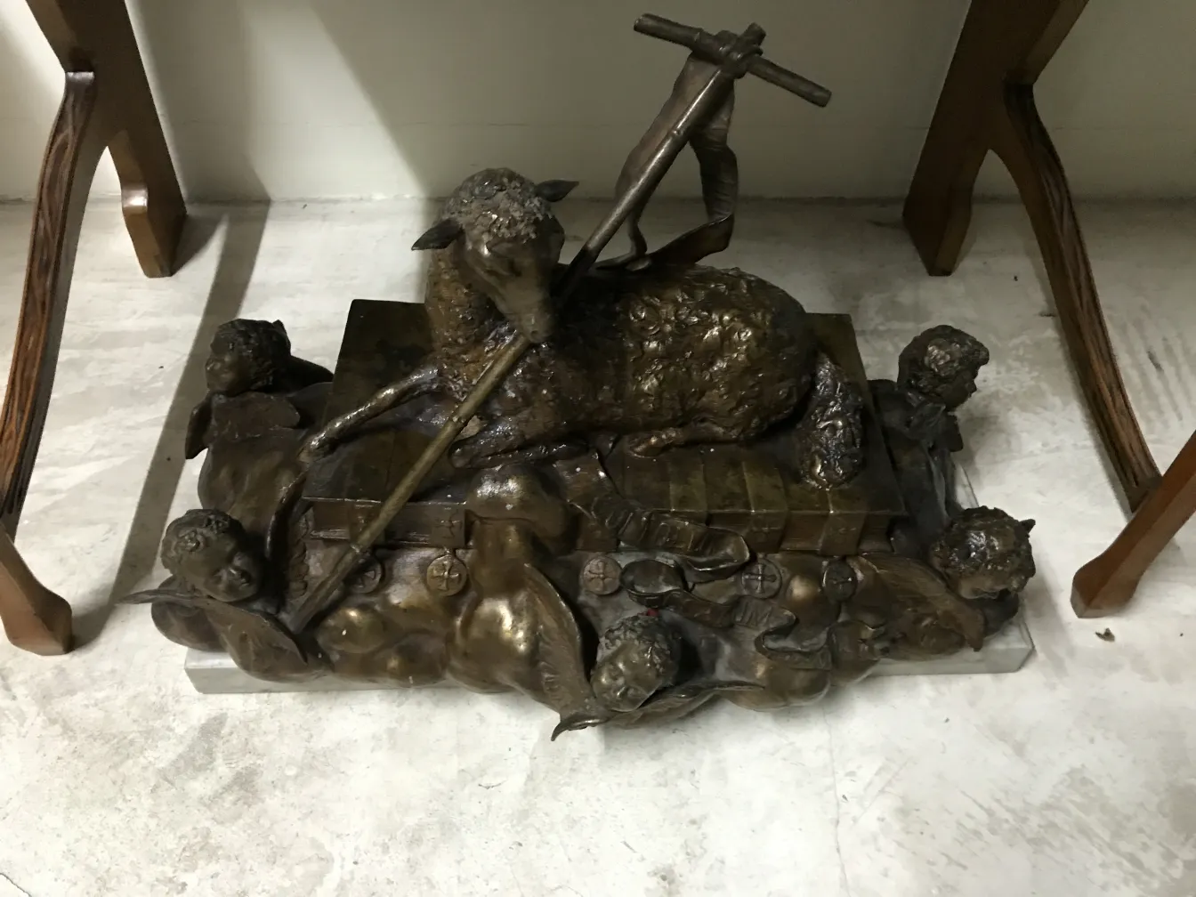 Sculpture ancienne représentant un mouton avec des enfants en train d'adorer, détails dorés, style classique.