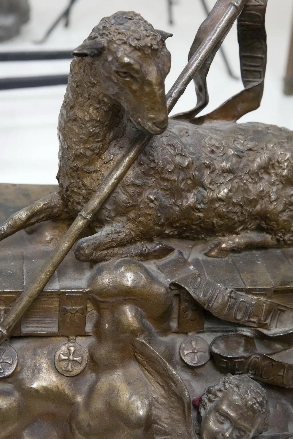 Escultura antiga de ovelha com figuras mitológicas distintas