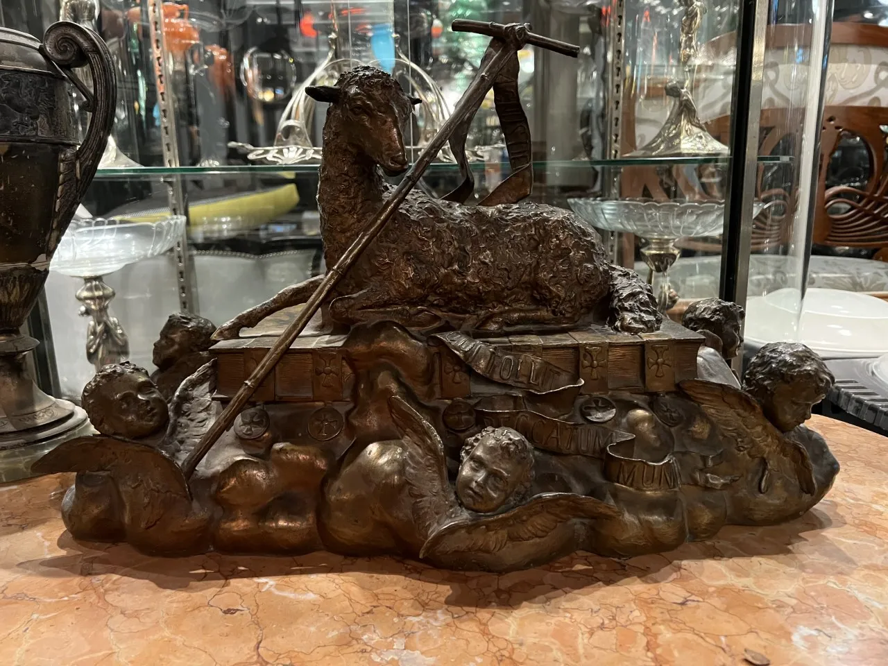 sculpture ancienne avec un agneau et des anges décoratifs.