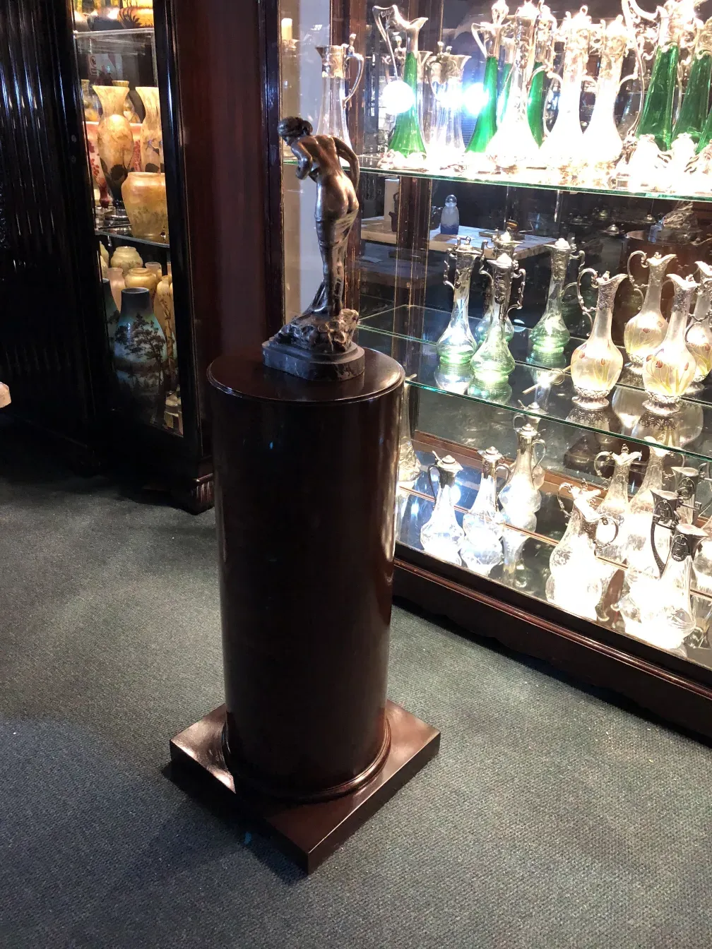 Coluna decorativa antiga com escultura em ambiente elegante