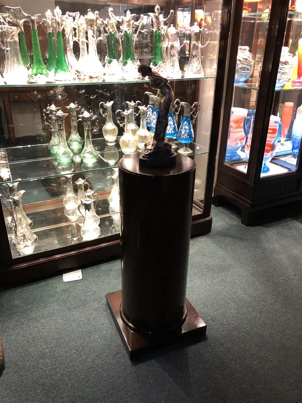 Black antique decorative column with a figure at the base.