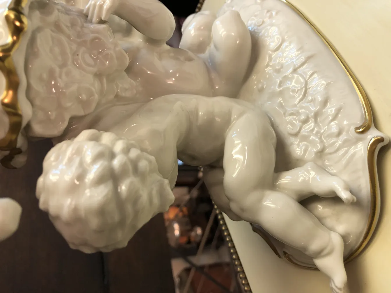 Antique white ceramic figure of a child with golden details, charming ambiance.