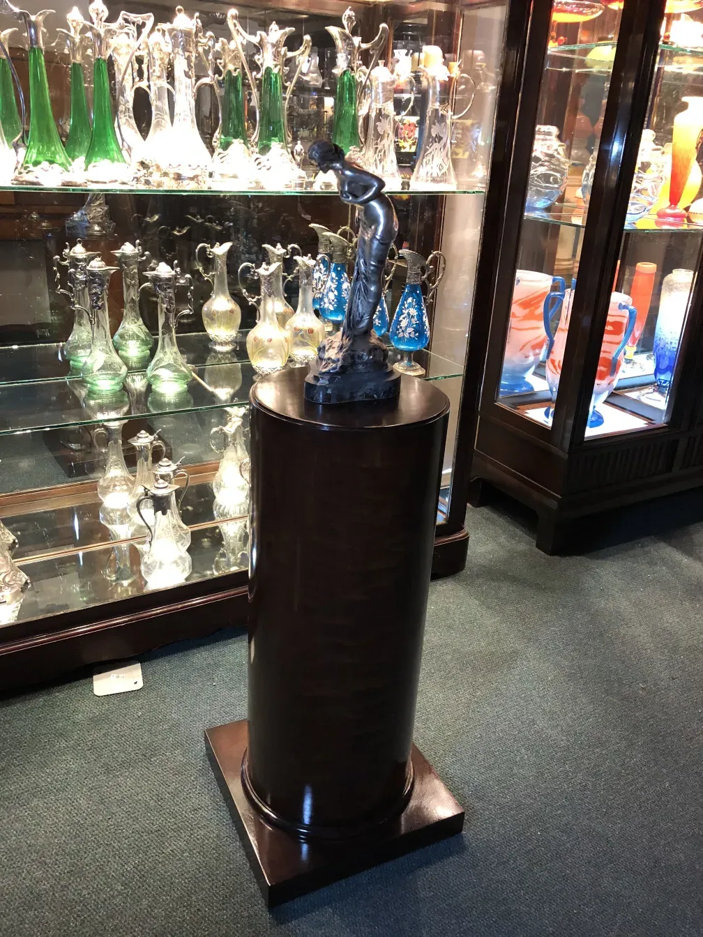 Columna antigua decorativa con figura, en ambiente de antigüedades