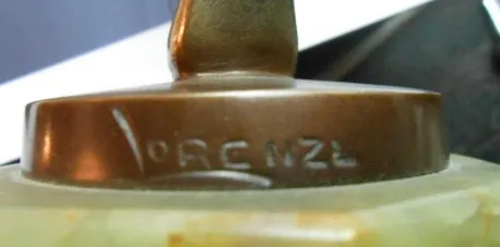 Scultura antica con firma visibile alla base, in un ambiente decorativo.