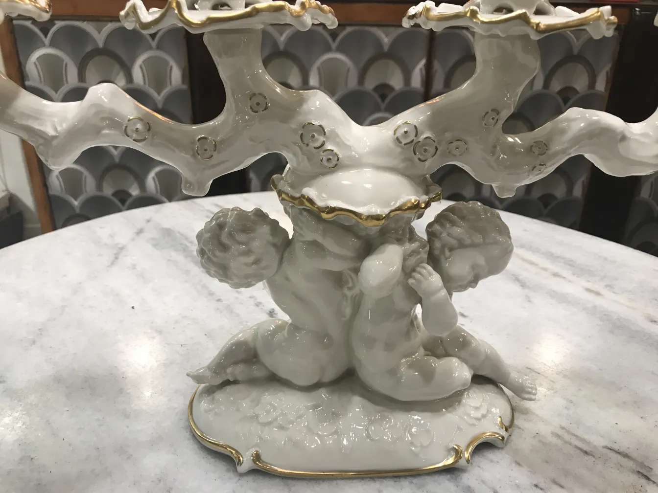 ornamento in ceramica antica con figure e rami decorativi