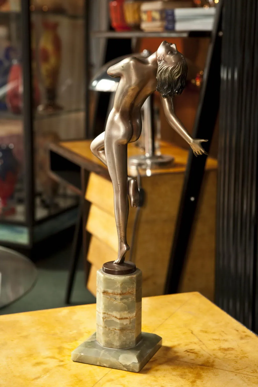 antike Frauenfigurenskulptur in dynamischer Pose auf Sockel